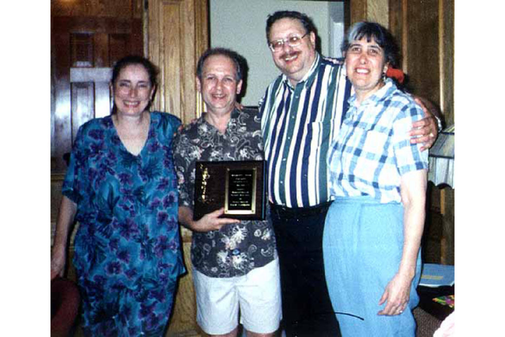 Denise and Bernie holding plaque with Art and Sue