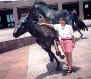 Sue Mayoff calms a (bronze) colt at Mustang Plaza in Las Colinas