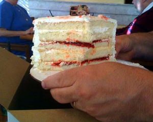 Slice of multi-layer cake being held by a hand