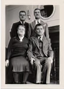 Small black and white photo of Israel Mayov and his wife seated, with their adult sons standing behind them.