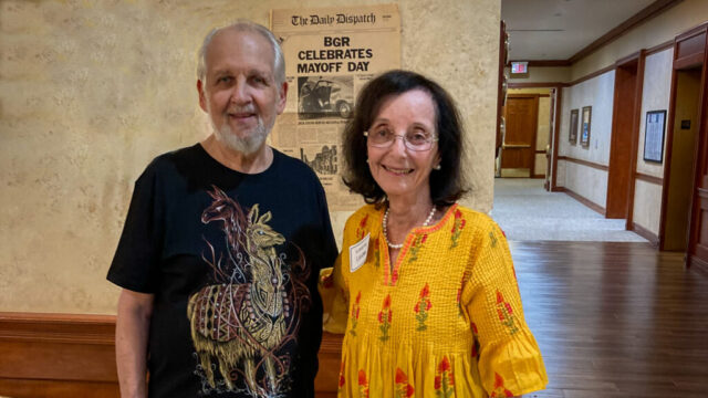 Bernie and Laraine bask in the glow after an evening of friendships renewed Photo of Bernie and Laraine in front of Mayoff Day newspaper headline