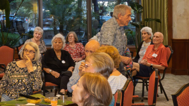 Art goes for another bellini Man walking through group of seated guests